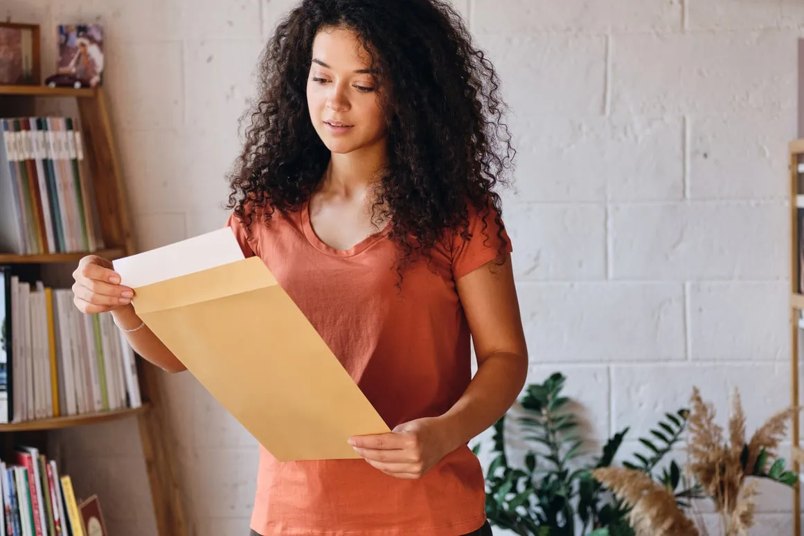 Lady taking printed documents out of an envelope